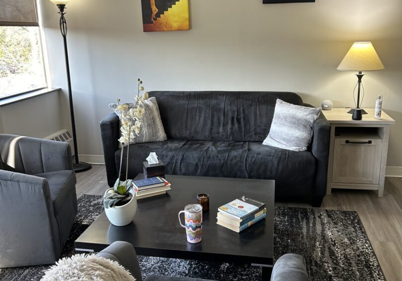 A living room with couches, chairs and tables.